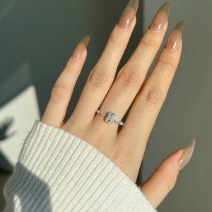 Close-up of S925 silver ring with 1ct emerald cut moissanite on a model finger