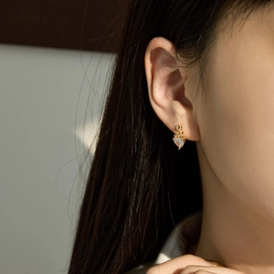 Gros plan d'une boucle d'oreille en argent S925 avec cœur en zircon et tête d'animal