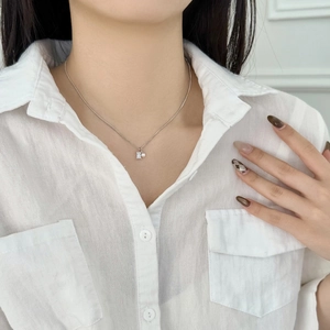 Close-up of S925 silver necklace with rectangular crystal and pearl on a white shirt