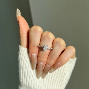 Macro shot of S925 sterling silver ring with emerald cut moissanite on finger