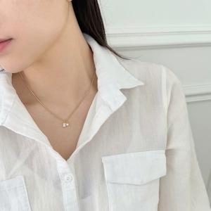 Close-up of a gold S925 sterling silver necklace with pearl and square zircon pendant