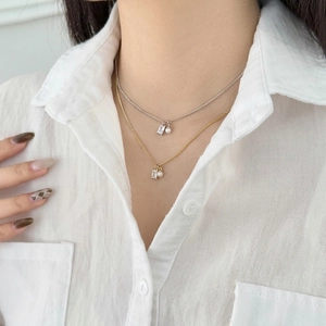 Elegant S925 sterling silver layered necklace with zircon and pearl on a white shirt