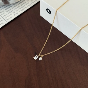 Detail of elegant gold S925 sterling silver necklace with sugar cube zircon and pearl