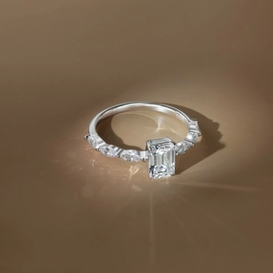 Macro detail of S925 sterling silver ring with emerald cut moissanite and side diamonds
