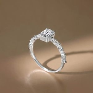 Macro shot of emerald cut moissanite ring with marquise accent diamonds on silver band