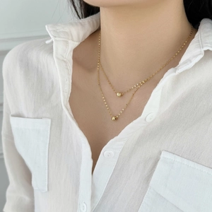 Elegant double-layered S925 sterling silver gold necklace featuring brushed bead pendants
