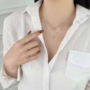 Close-up of a double-layered S925 sterling silver necklace with minimalist beads