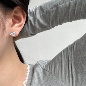 Close-up of S925 sterling silver square-cut stud earrings worn on an earlobe