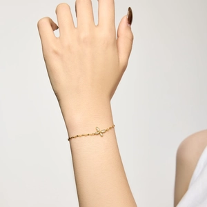 Elegant gold butterfly bracelet with crystal pendant worn on a female wrist