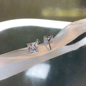 Macro detail of S925 sterling silver princess cut square stud earrings in 4-prong setting
