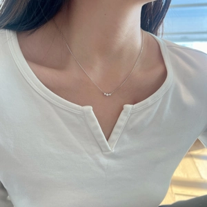 Close-up of minimalist S925 silver necklace with three round zircons on a female model