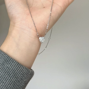 Collier cœur en argent S925 avec pendentif moissanite de 2 carats tenu en main