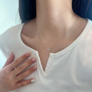 Close-up of S925 sterling silver necklace with three sparkling small round diamonds