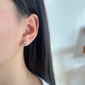 Close-up of minimalist S925 silver round stud earring with brilliant moissanite on model