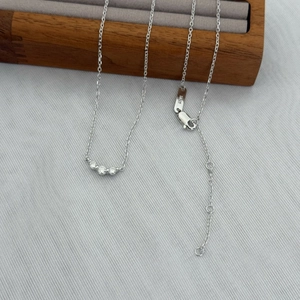 Detail of S925 sterling silver necklace with three round-cut sparkling stones and lobster clasp