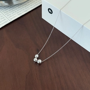 Macro shot of minimalist S925 sterling silver necklace with three polished round beads