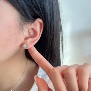 Close-up of minimalist S925 sterling silver stud earring with bezel-set round diamond stone