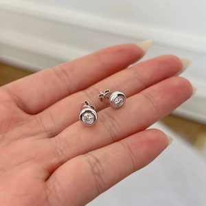Close-up of S925 sterling silver bezel-set stud earrings with round moissanite stones