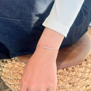 Close-up of S925 silver bracelet with smiling curved row of round Moissanite stones