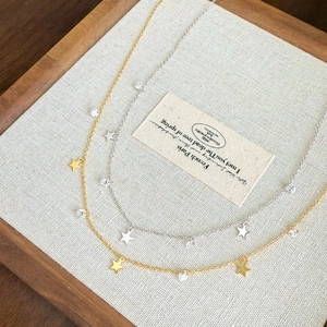 Exquisite S925 sterling silver necklace featuring star pendants and zircon accents in a wooden tray