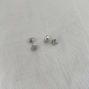 Close-up of S925 sterling silver stud earrings with round-cut sparkling moissanite stones