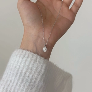 Detail shot of a 1.5 carat oval-cut moissanite pendant on a delicate S925 silver chain