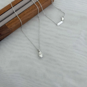 S925 sterling silver necklace with 1.5ct oval moissanite pendant on a wooden display