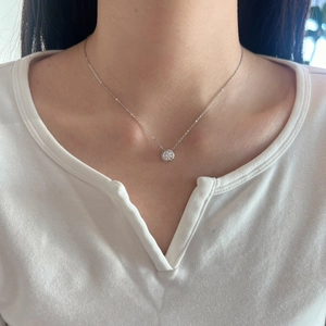 Close-up of S925 sterling silver necklace with a round-cut moissanite pendant on neck
