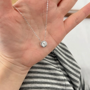 Detail of S925 silver necklace with sparkling solitaire round moissanite pendant
