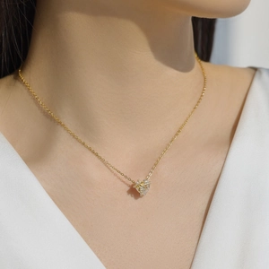 Dettaglio della collana con pendente a stella scintillante in oro indossata da modella