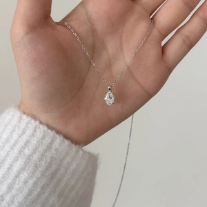 Minimalist S925 silver necklace with 1.5ct oval moissanite pendant held in palm