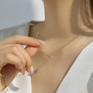 Primo piano di una collana a stella dorata con pendente in zircone indossata da una modella