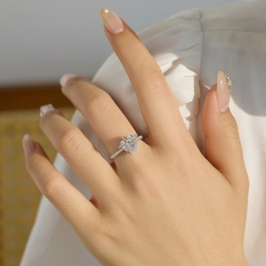 Dettaglio anello in argento S925 con cuore di diamante e pavé sulla mano di una modella