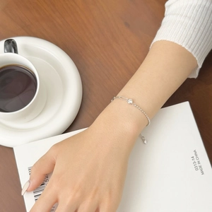 Close-up of S925 sterling silver chain bracelet featuring a round zircon on a wrist