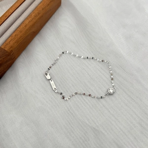 Detail of S925 sterling silver bracelet with lobster clasp and round solitaire pendant