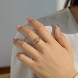 Dettaglio di un anello in oro con grande zircone brillante e diamanti sulla mano