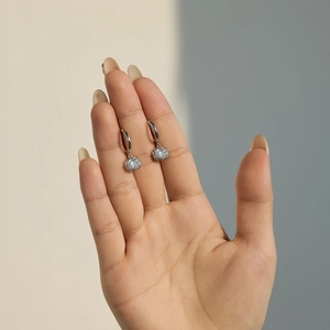 Detail view of silver S925 sterling silver hoop earrings with clear round cubic zirconia