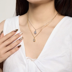 Détail de colliers superposés en argent S925 avec pendentifs goutte taille poire