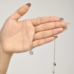 Vue détaillée du collier avec pendentif goutte en forme de poire sur la main