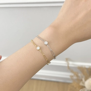 Elegant gold and silver hybrid chain bracelet with a central zircon stone on wrist