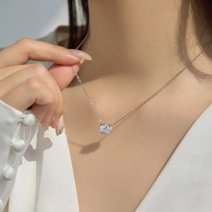 Close-up of S925 sterling silver necklace with a sparkling round solitaire pendant on model
