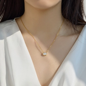 Close-up of elegant gold necklace with a sparkling round solitaire pendant on a model