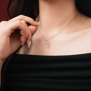 Detail of S925 sterling silver necklace with pink pavé four-leaf clover pendant on neck