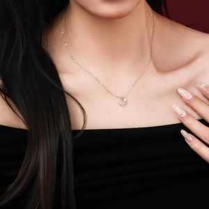 Close-up of S925 silver necklace featuring a delicate pink zircon clover pendant on model