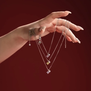 S925 sterling silver clover necklaces with pink, yellow and purple gems on red backdrop