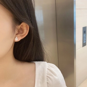 Close-up of elegant S925 sterling silver moonstone stud earring worn on model's ear