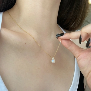 Détail d'un collier en argent S925 doré avec pendentif en pierre de lune sur le cou