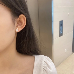 Close-up of elegant S925 silver moonstone earring with zircon inlay worn by a model