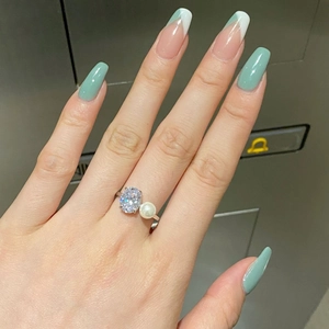 Détail d'une bague en argent S925 avec zircon ovale et perle blanche sur la main d'un mannequin