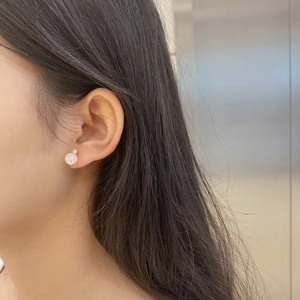 Close-up of S925 sterling silver moonstone stud earrings with sparkling zircon on earlobe
